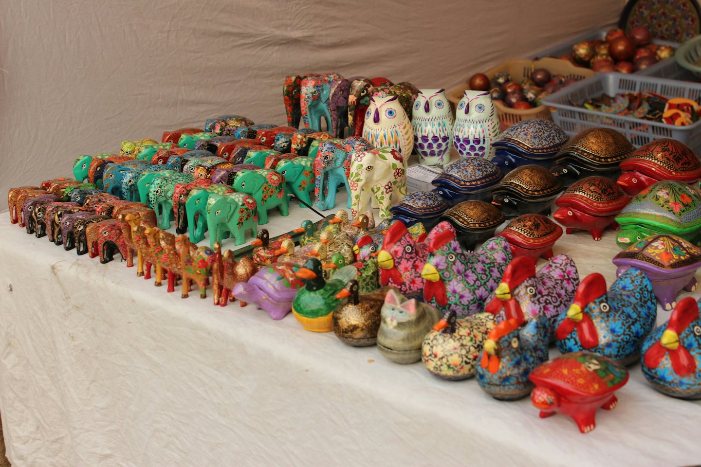 Hand-painted animal figurines are arranged on a white table.